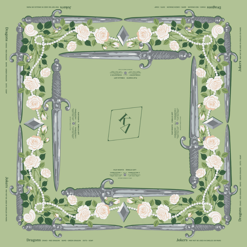 Kappa Delta MIGTM Mahjong Mat featuring a sage green background with a border of silver swords, pale pink roses, green leaves, and white pearl-like chains. The center has a small green square with a stylized symbol, and the words 'Dragons' and 'Jokers' appear at the top and bottom.